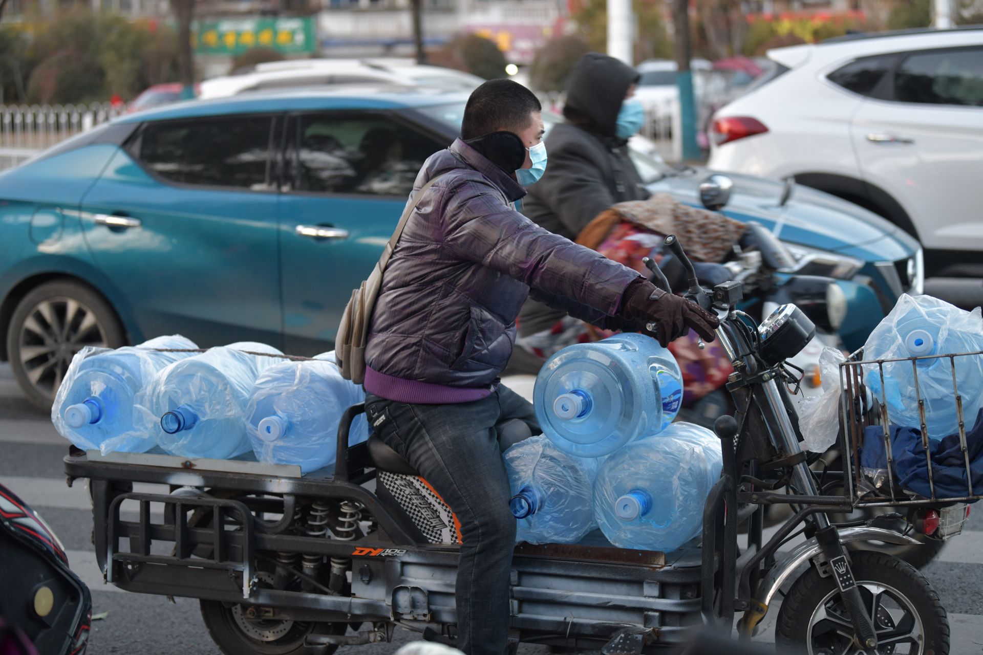 送水工冒着严寒将水送到千家万户寒风中,东海大道一名辅警正在指挥